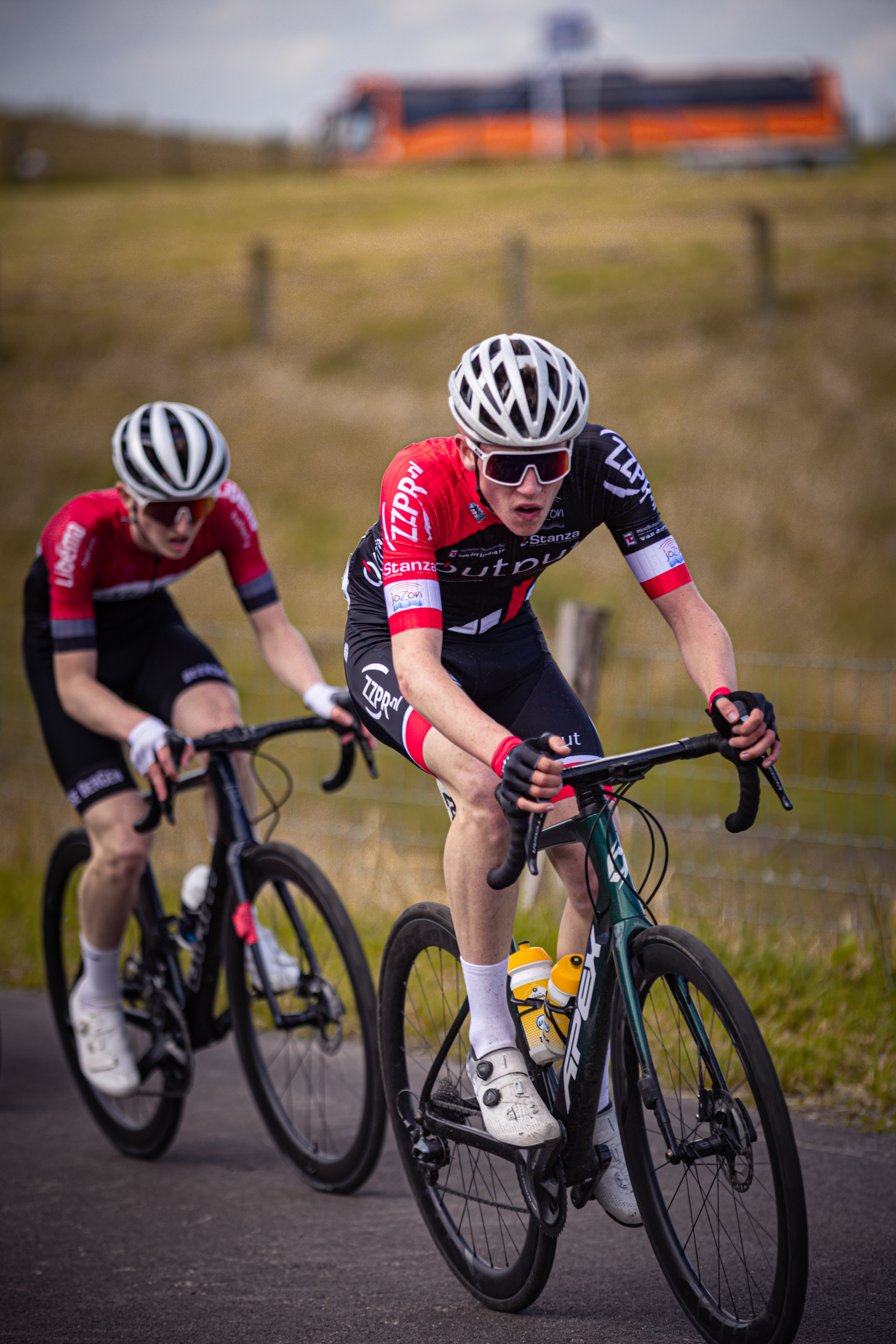 Two cyclists racing in a Nederlands Kampioenschap event, sponsored by Wielrennen.