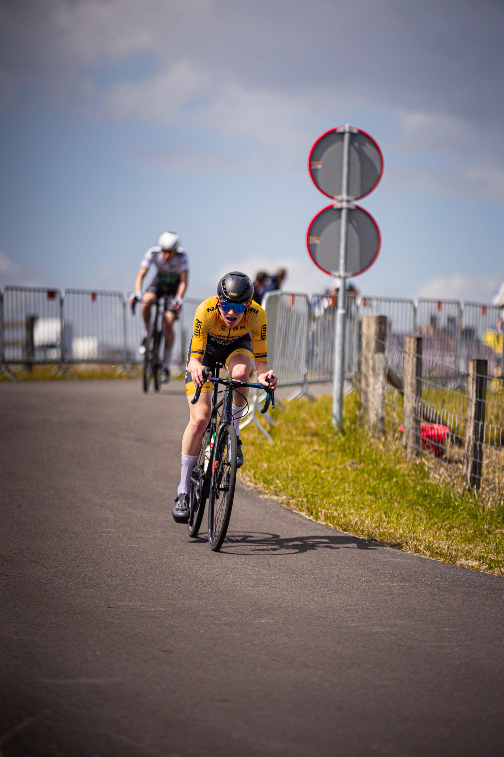 Three cyclists racing on a track at the Nederlands Kampioenschap.