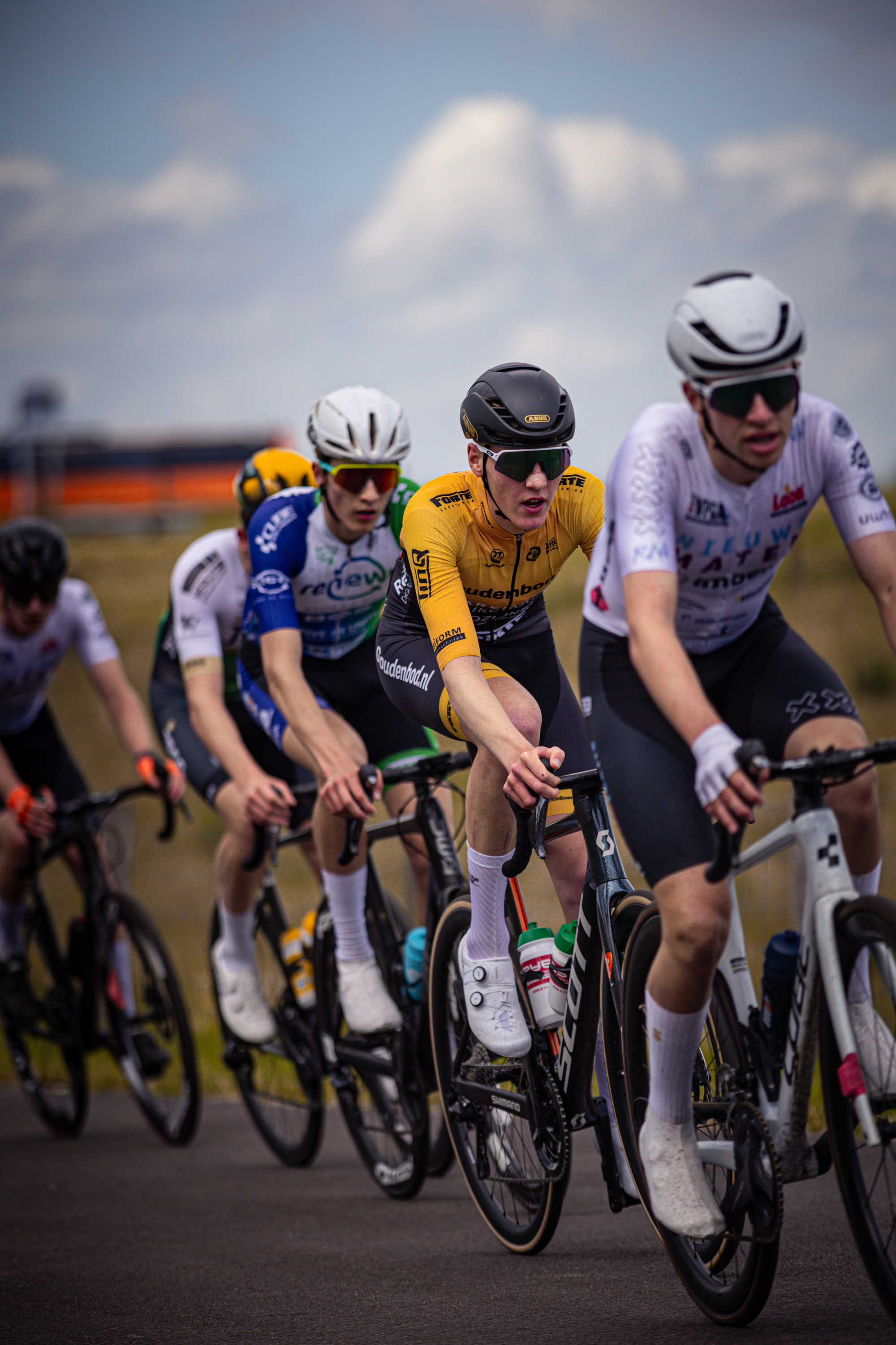 A group of cyclists wearing helmets are racing in a race.