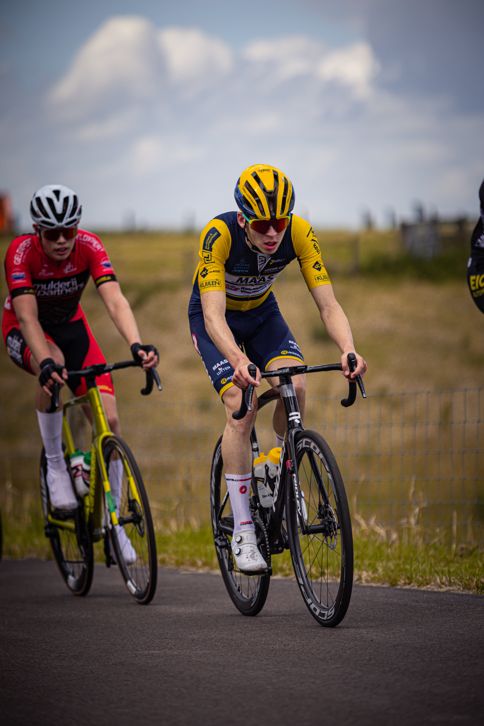 Two cyclists in a race, wearing numbers 1 and 5, are seen from the side.