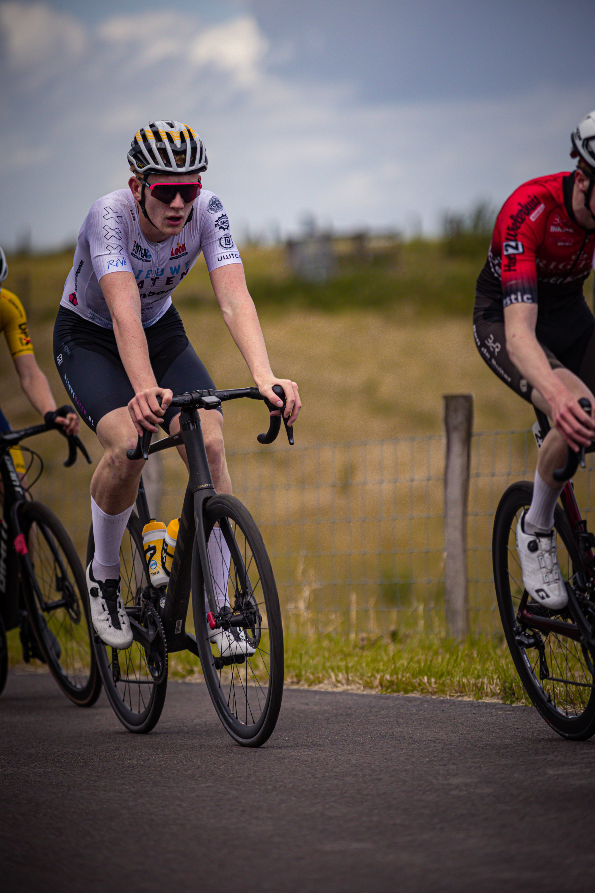 Two cyclists race on a road at the Nederlands Kampioenschap.