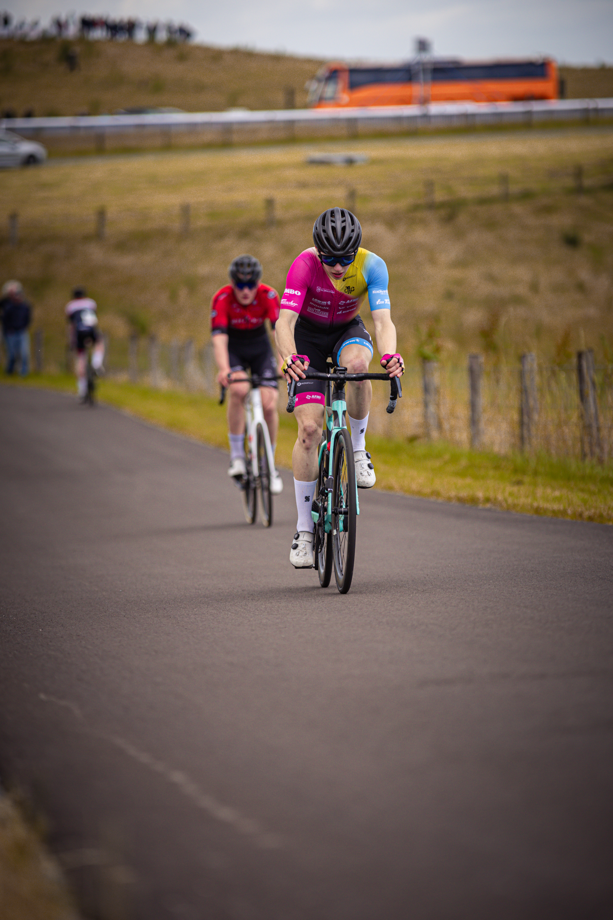 Three people are participating in the Nederlands Kampioenschap of cycling.