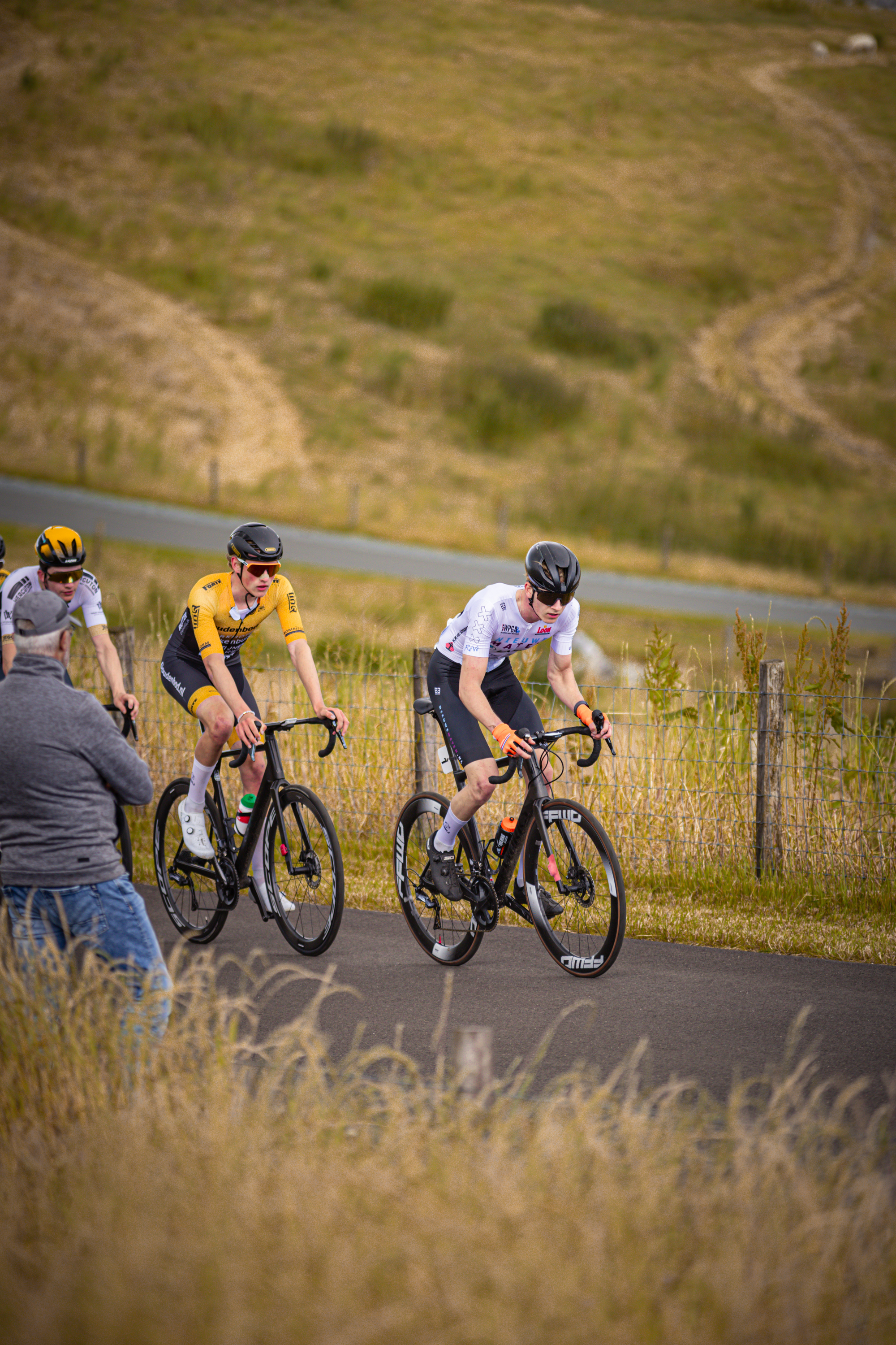 Three cyclists in a race, one of them is wearing number 17.