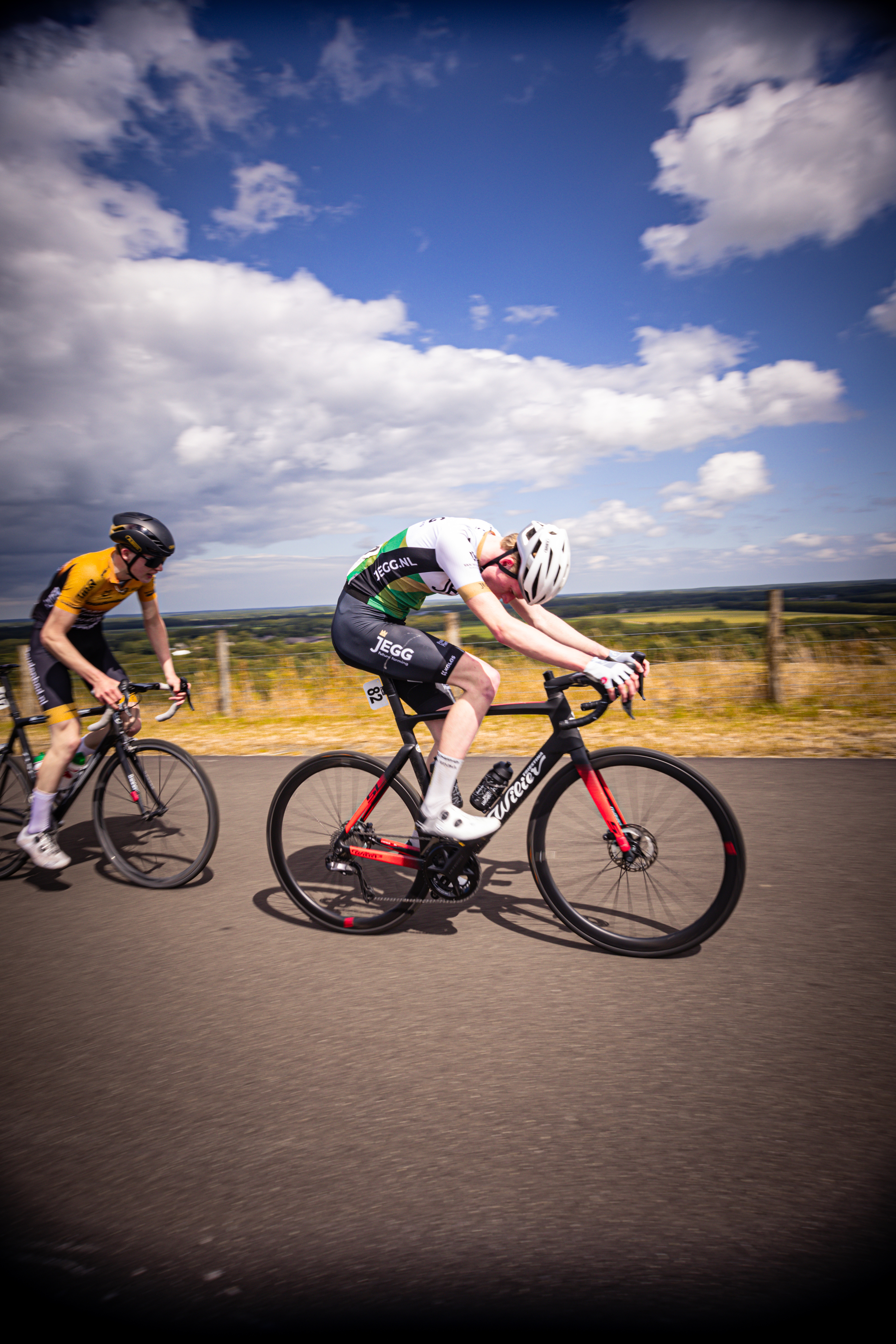 A couple of men race their bikes at the Nederlands Kampioenschap Wielrennen.