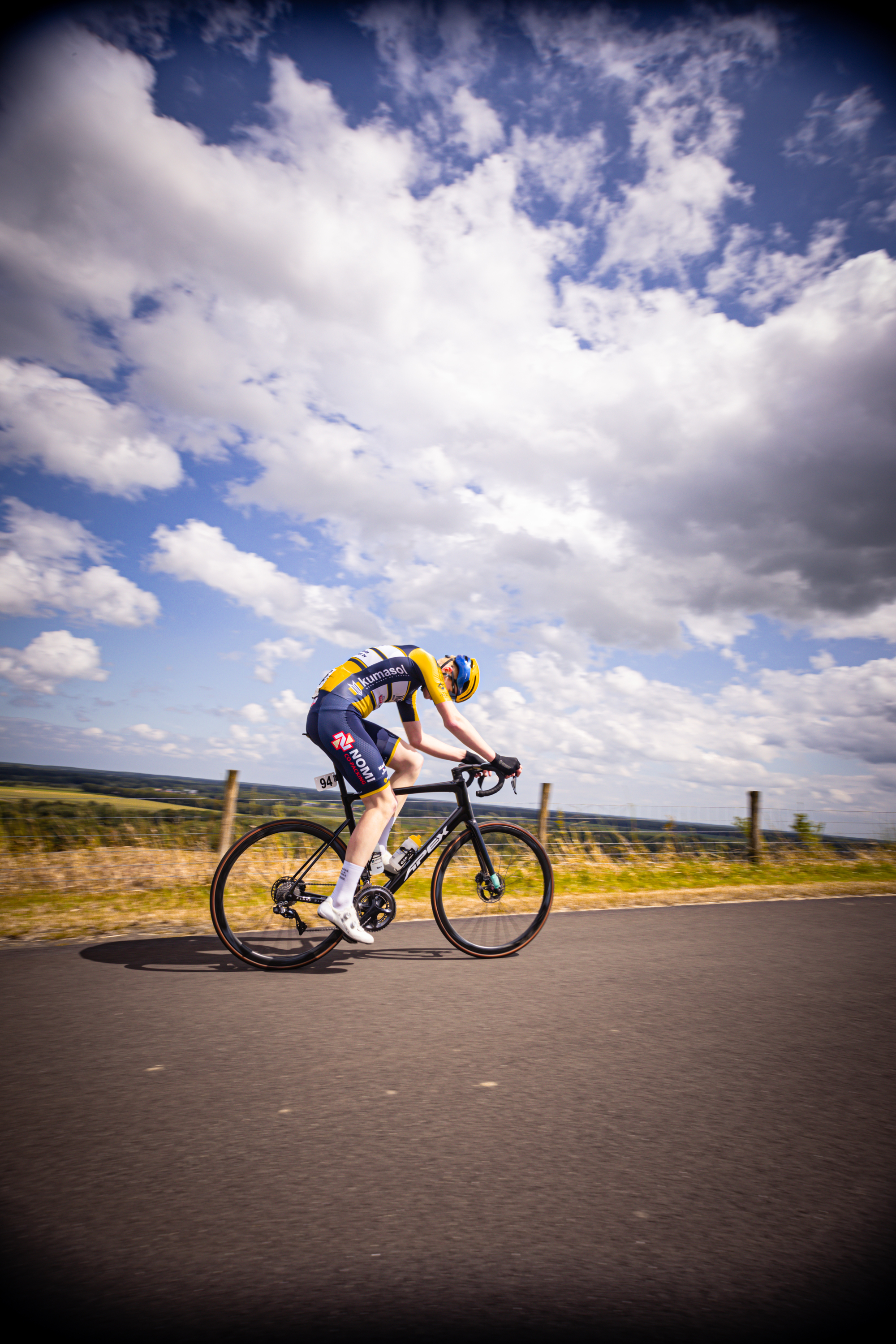 A cyclist on a road with his arms spread wide and wearing the number 1.