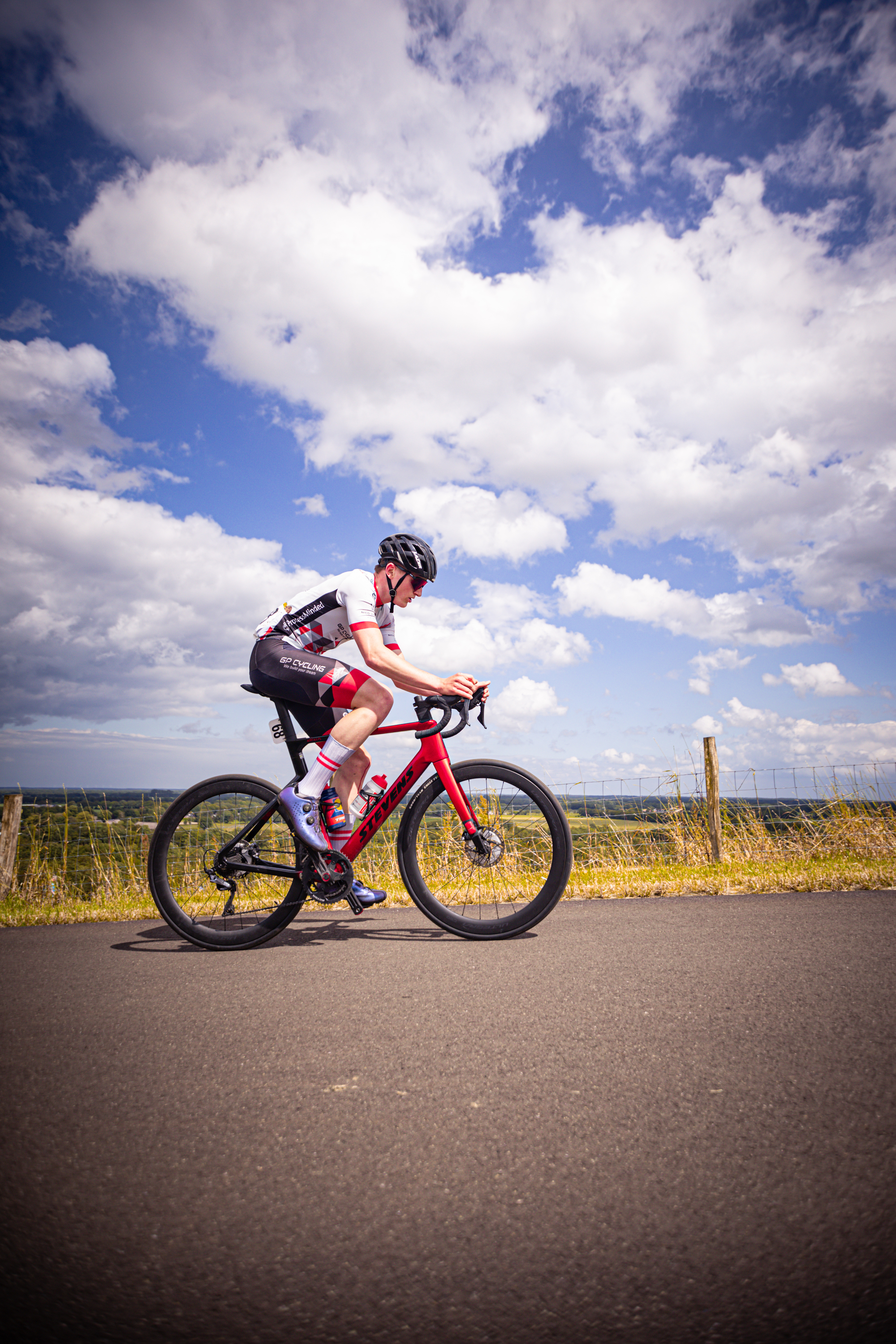 A person in a red and black shirt riding on a red bike.