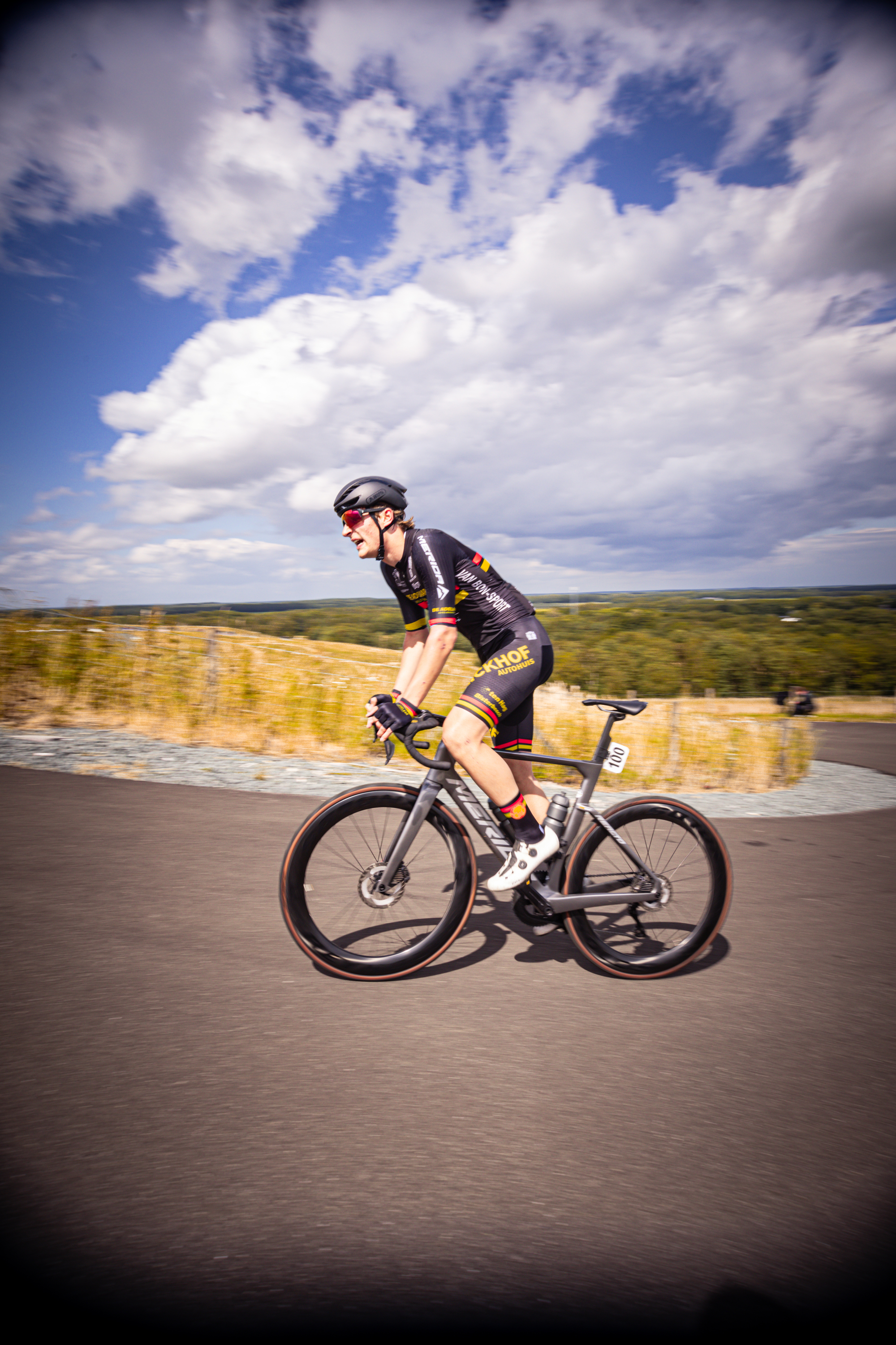 A person on a bicycle wearing a black and yellow racing uniform with the number 1 on the back.