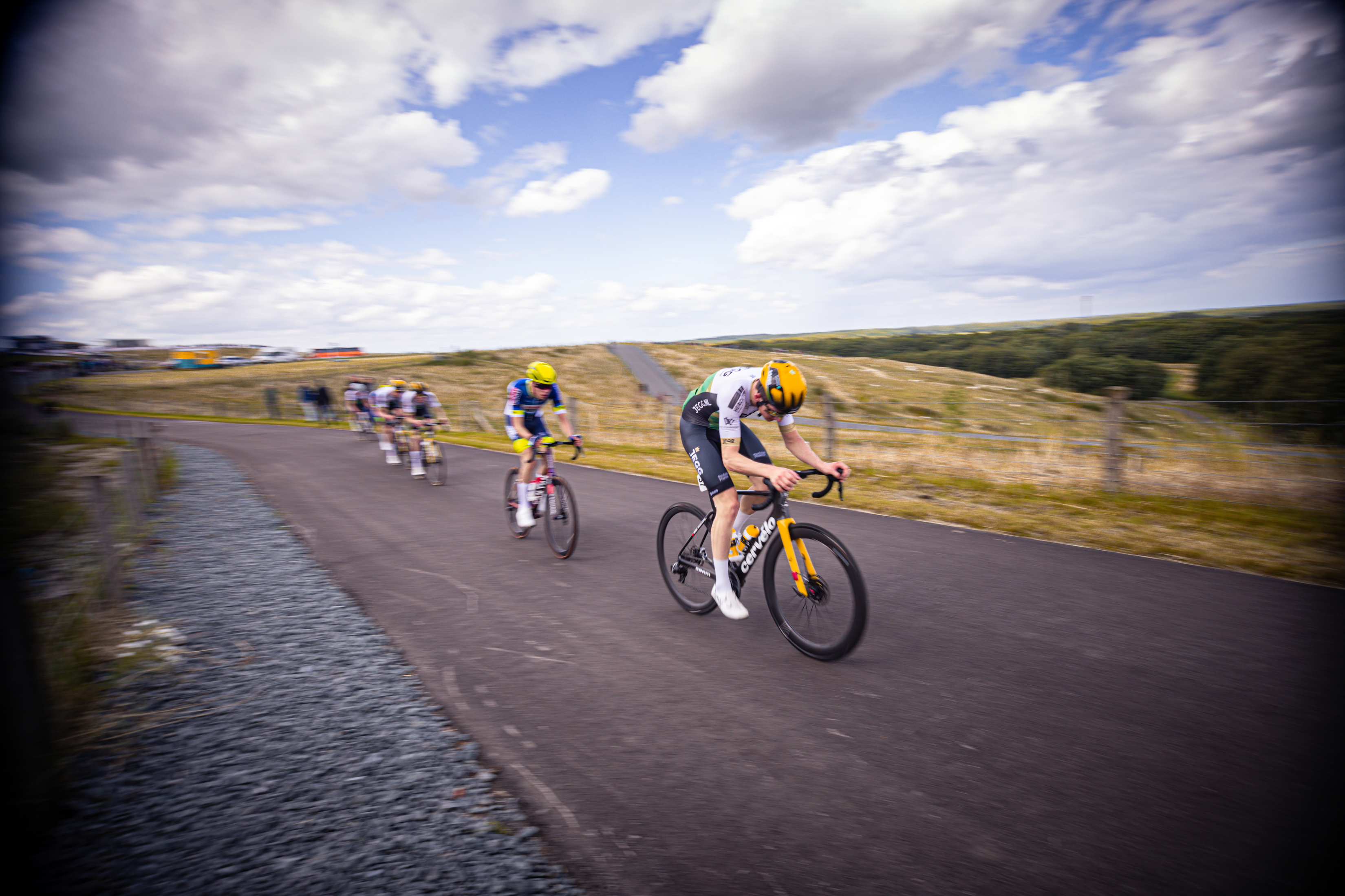 A group of cyclists racing in a Nederlands Kampioenschap, including one wearing the number 1.