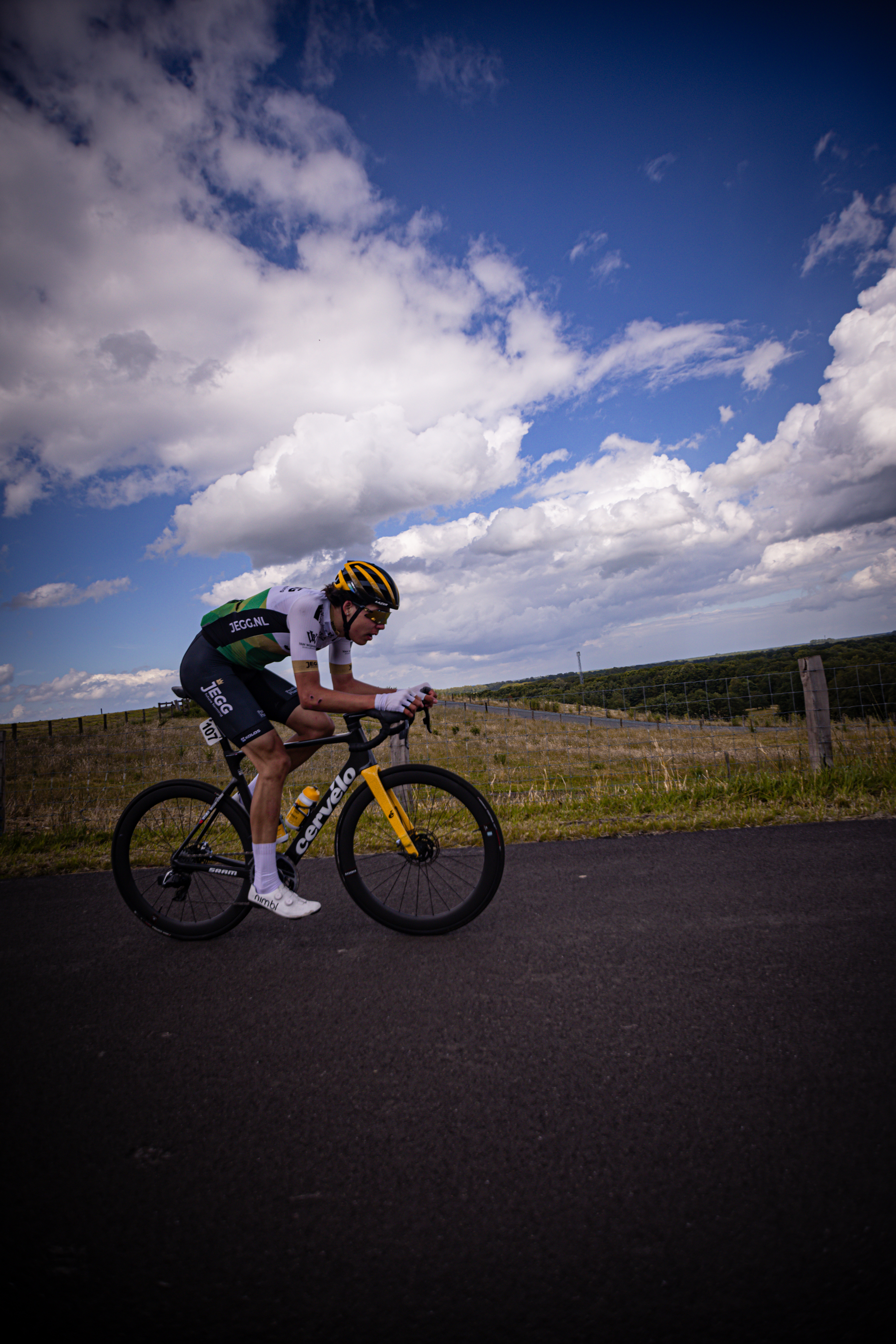 A man riding a bike wearing the number 27 on his jersey.