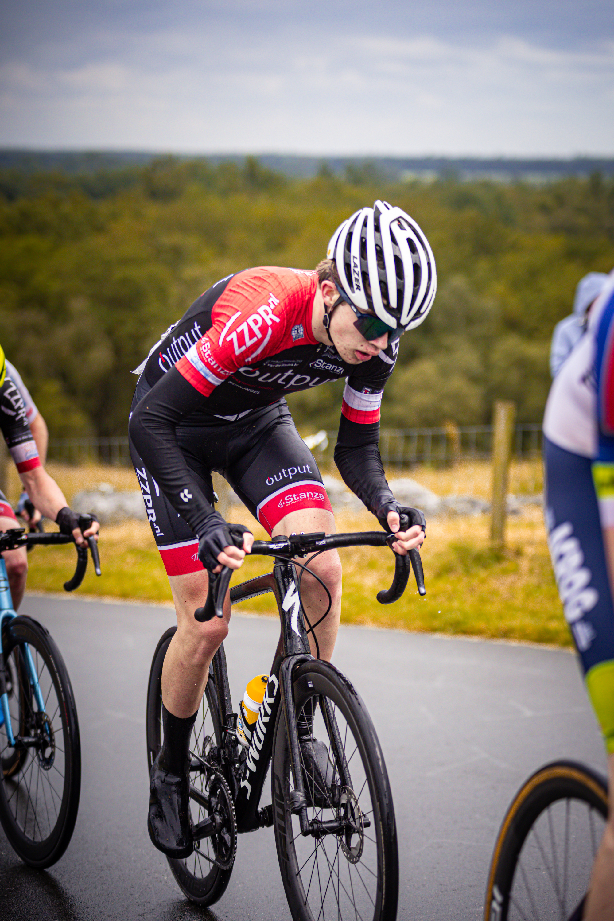 A cyclist with a white helmet is wearing a jersey with the word "team" on it.