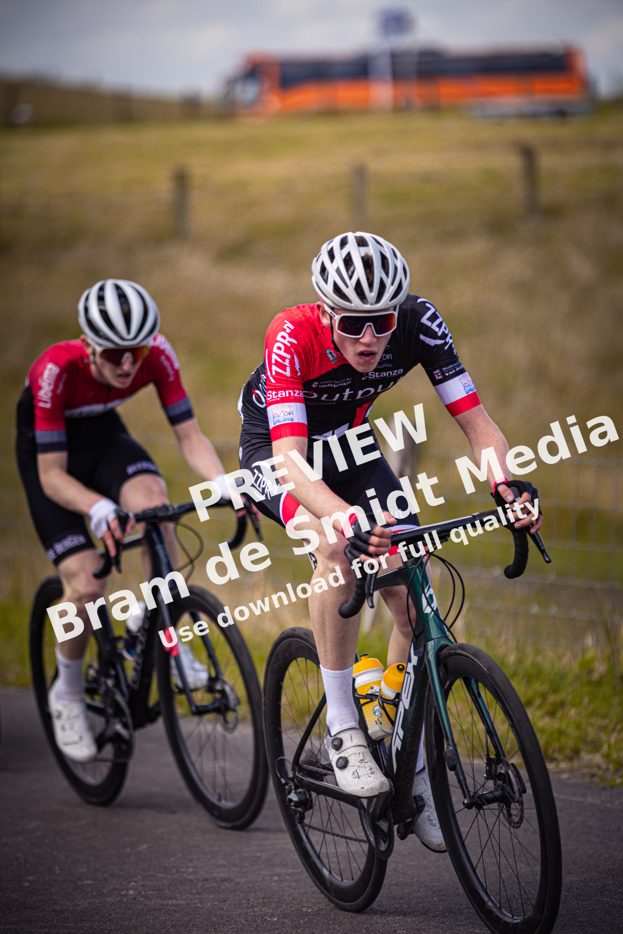 Two cyclists racing in a Nederlands Kampioenschap event, sponsored by Wielrennen.