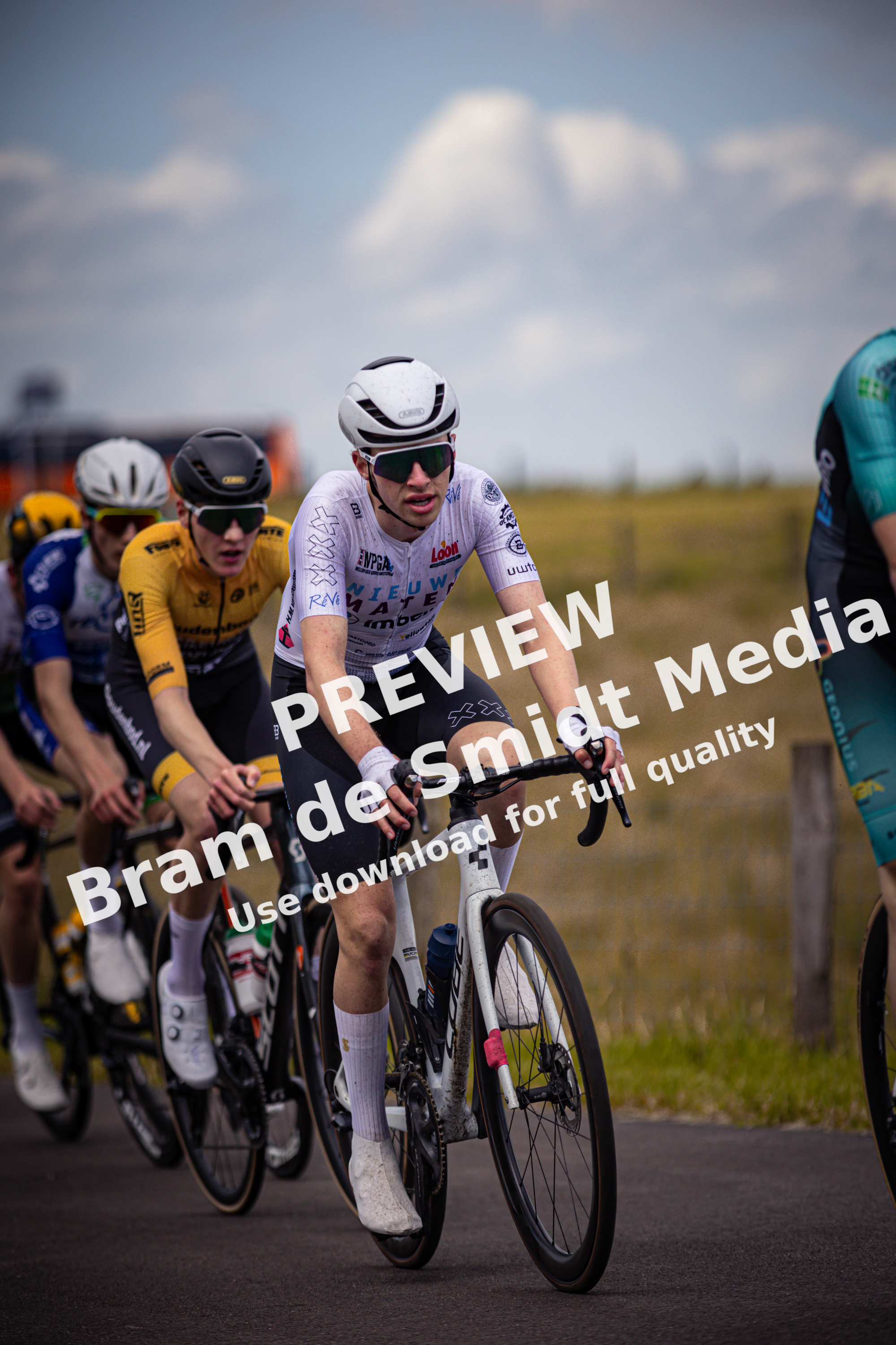 The cyclists are participating in a race, one of them is wearing a black outfit with the number 24 on it.