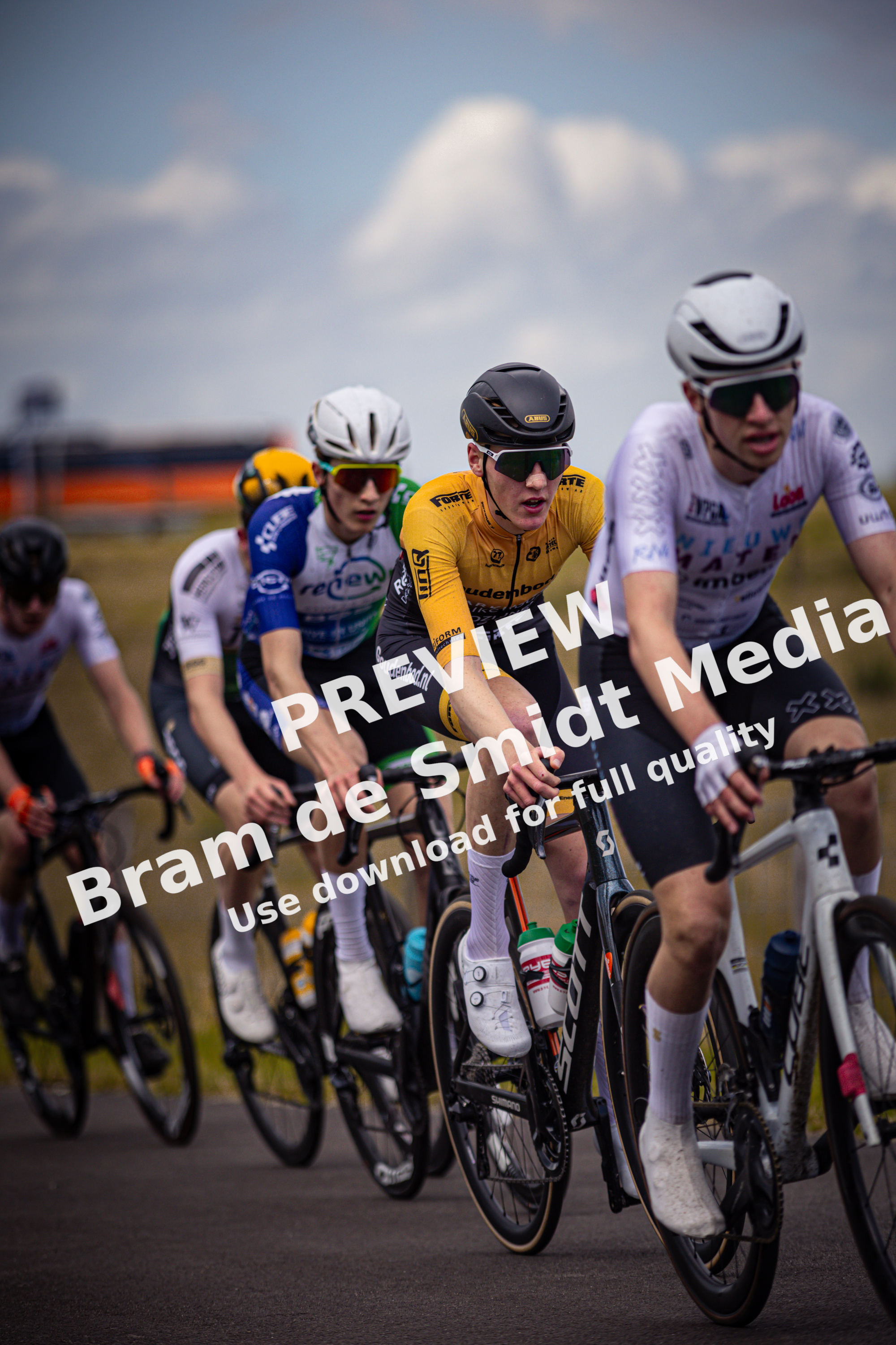 A group of cyclists wearing helmets are racing in a race.