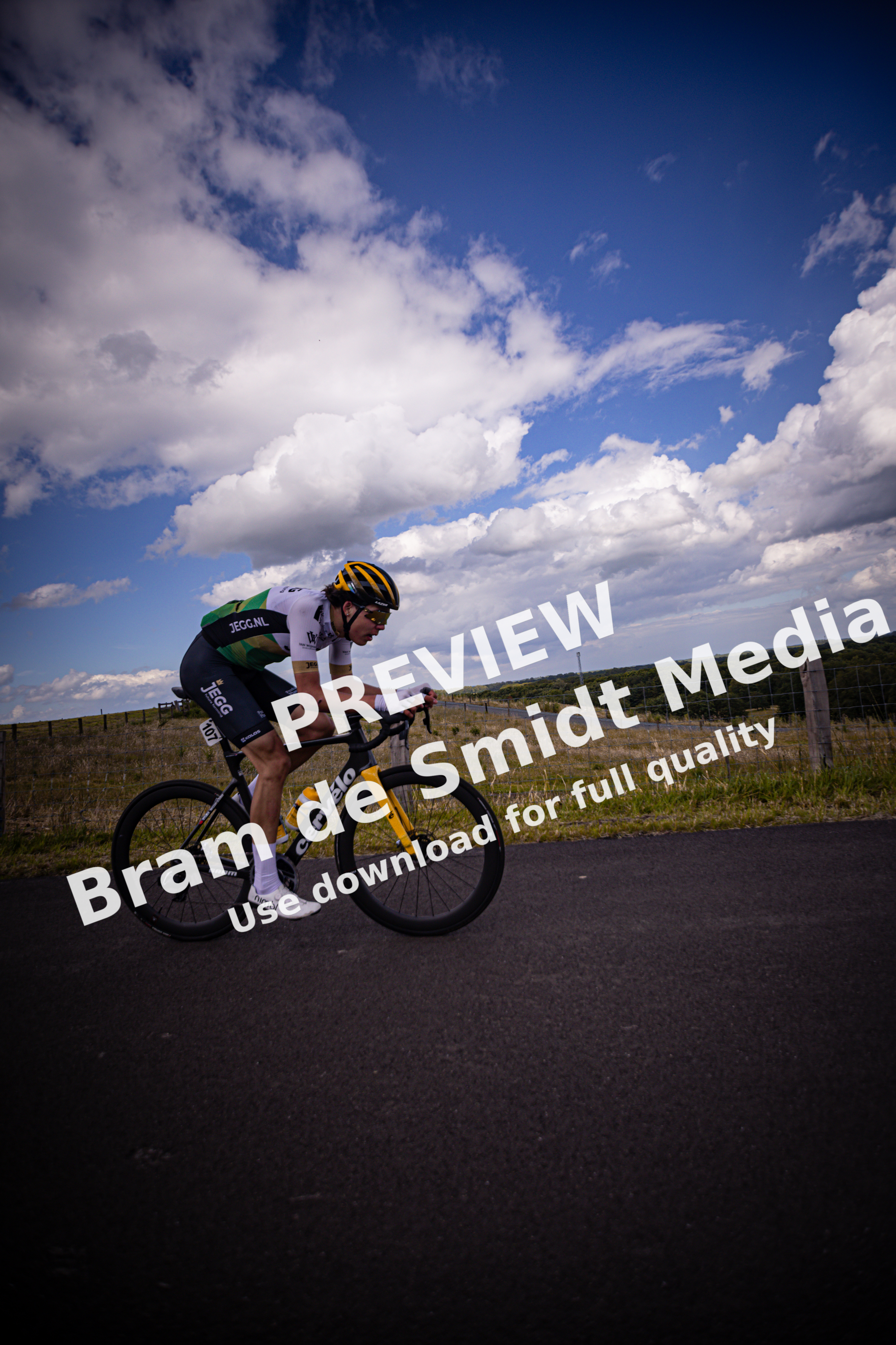 A man riding a bike wearing the number 27 on his jersey.