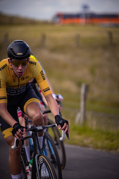 Two cyclists are riding on a road for the Netherlands Championships.