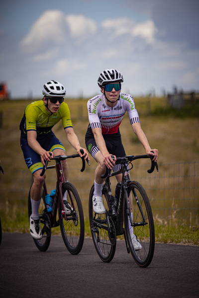 Two cyclists race down the street for the Nederlands Kampioenschap.