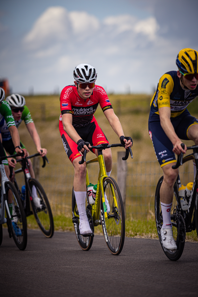 Three cyclists racing on a road during the Netherlands Championships in 2024.