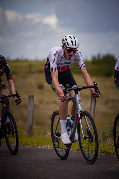 A picture of a young man wearing sunglasses while riding a bicycle.