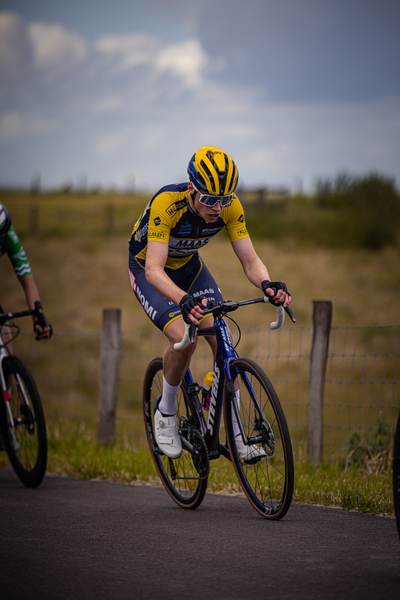 Two cyclists are racing on a track during the Nederlands Kampioenschap.