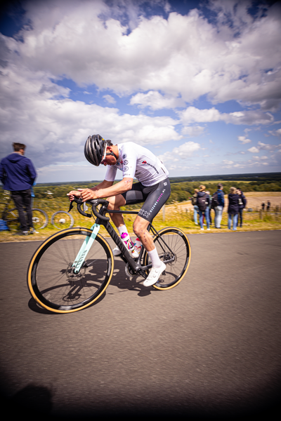 A man on a bicycle with the words KAMPIONATESCHAP on his shirt.