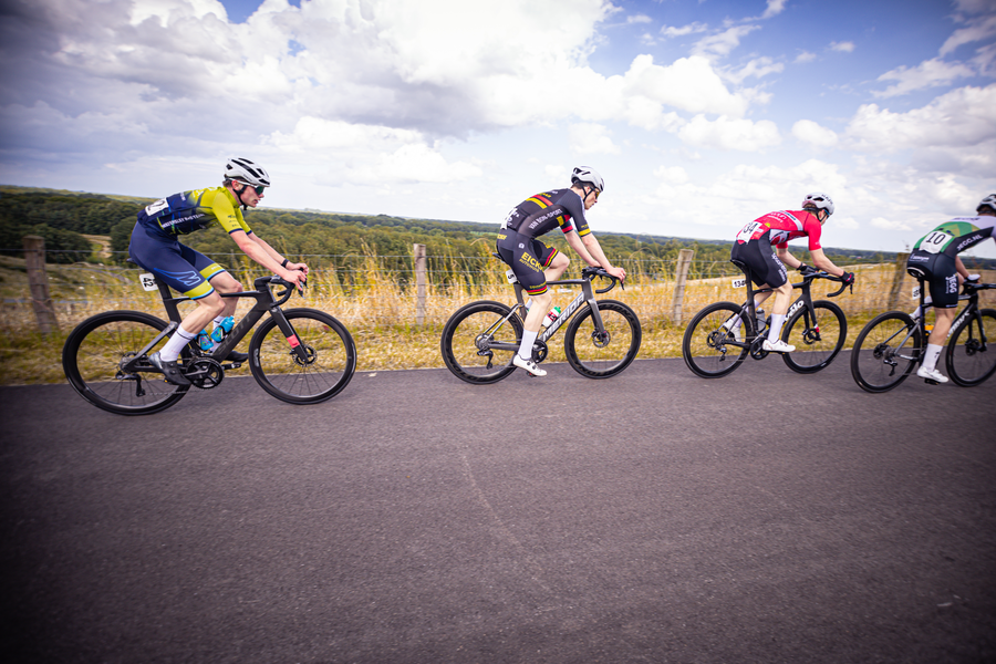 A group of cyclists are racing down the road in a competition.