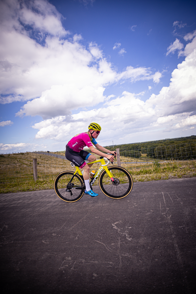 A person is riding a yellow and black bike with the word "Junioren" written on it.