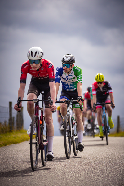 Junioren Mannen race participants are on a paved road.