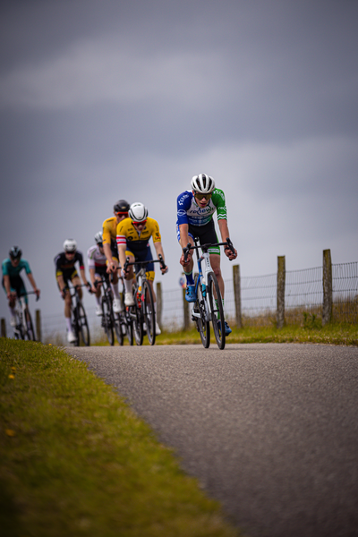 A group of cyclists wearing blue and yellow uniforms participate in a race.