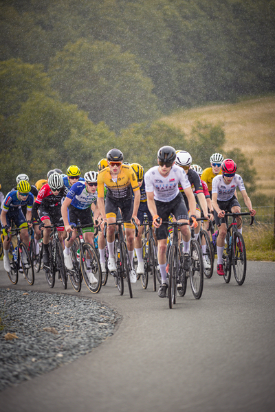 A group of cyclists race down a road as part of the Nederlands Kampioenschap.