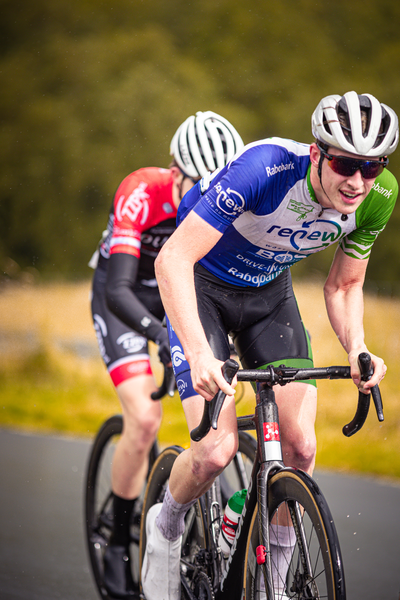 Two cyclists compete in a race sponsored by Nederlands Kampioenschap.