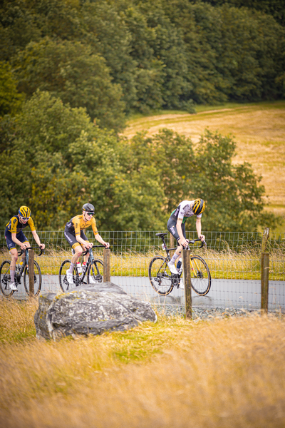 A cyclist wearing yellow jumps over a boulder on the track at the Nederlands Kampioenschap.