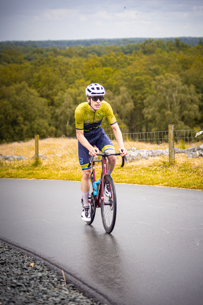 Junioren Mannen wielrennen racer wearing yellow and blue bike jersey on his back.