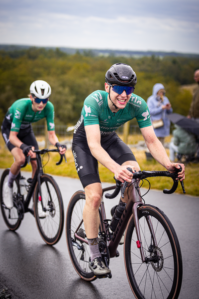 Two cyclists racing in the Netherlands, one wearing a green shirt.