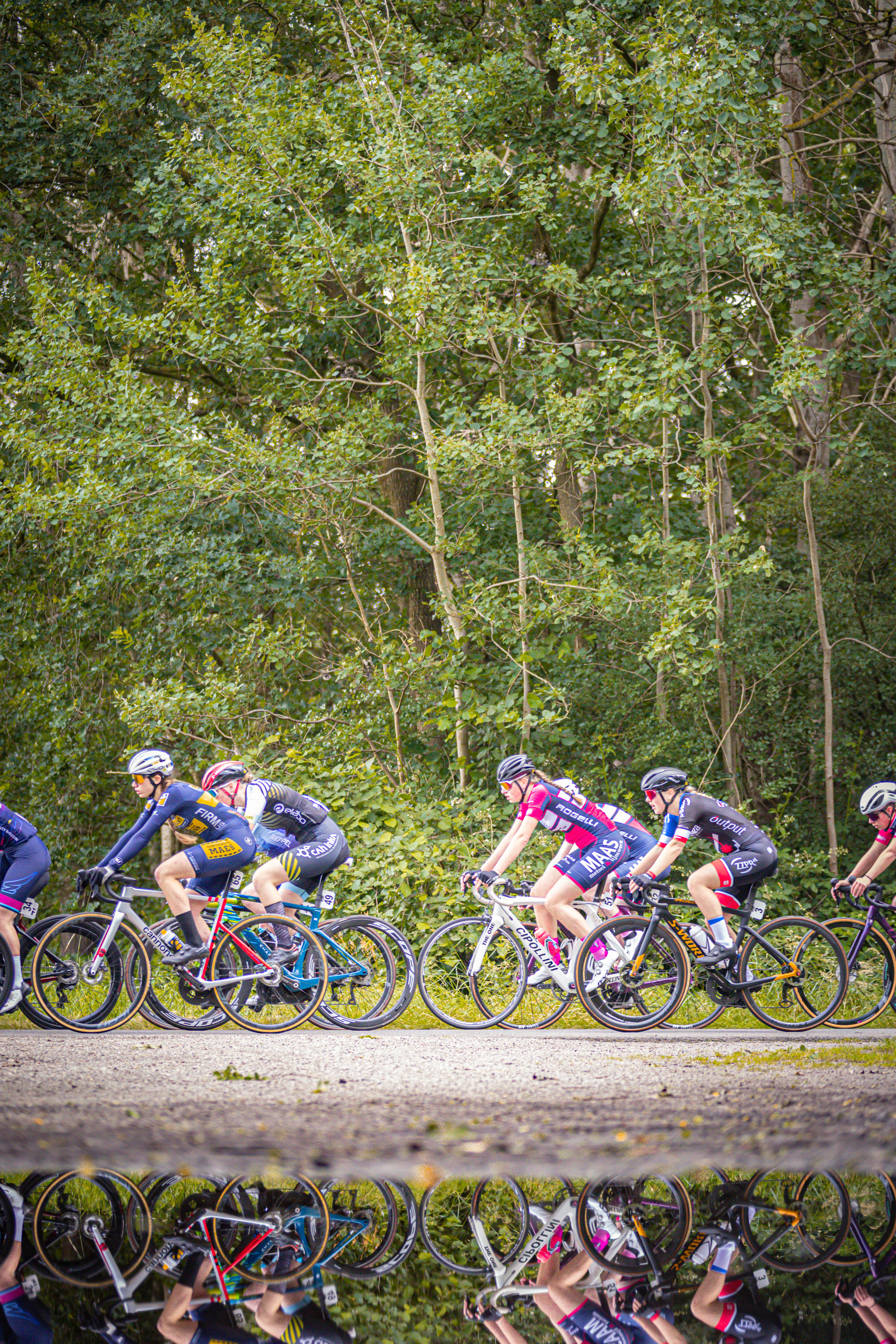 A group of bicyclists, all dressed in black and white, are competing in a race.