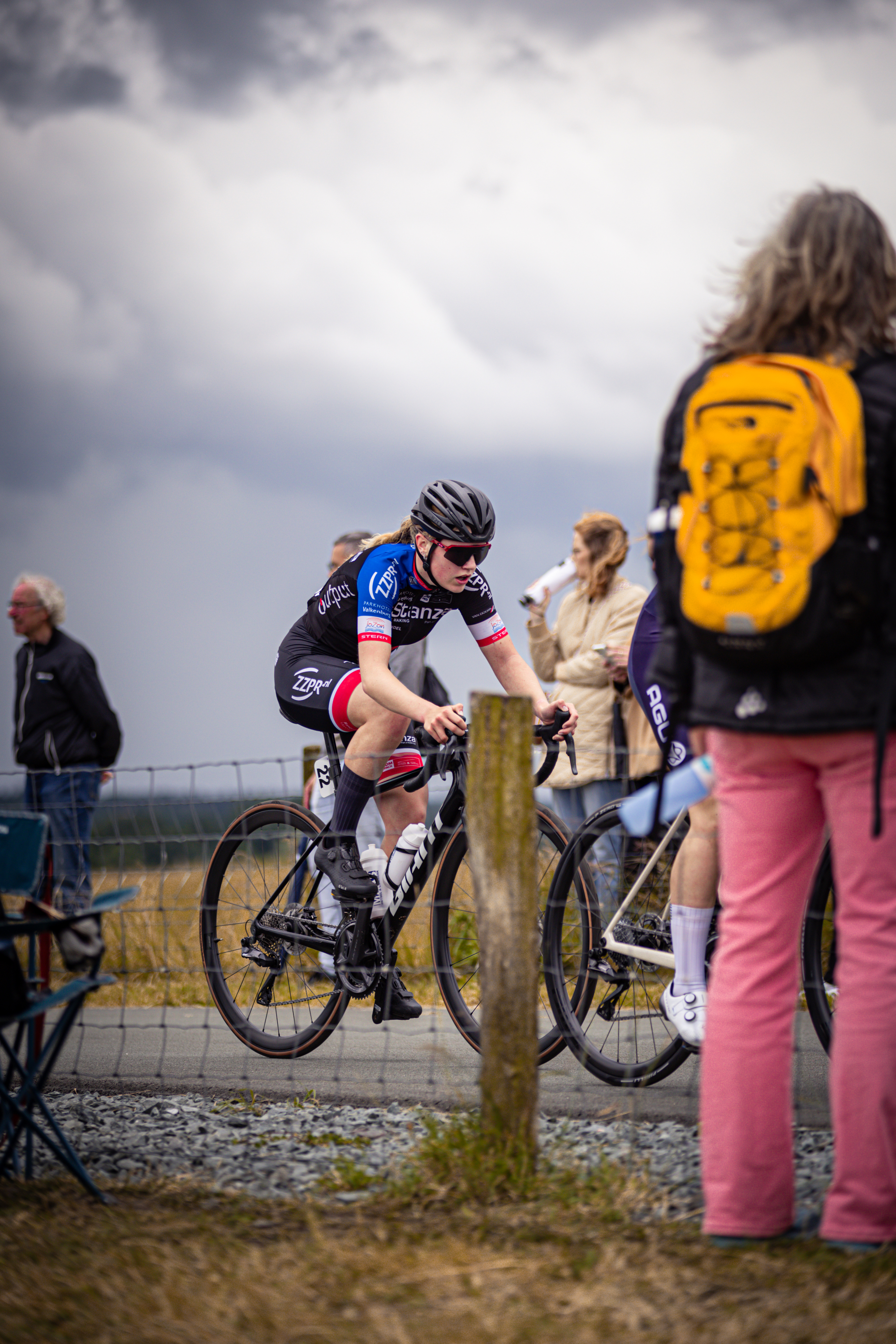 A woman riding a bike and the words "Junioren Dames" on her shirt.