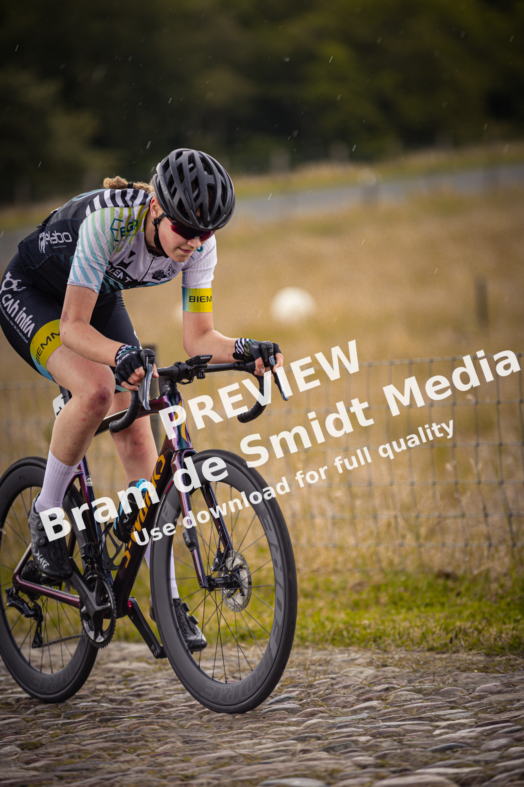 A young girl riding a bike and has the number 9 on her.