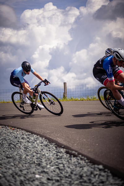 Two people are riding bicycles near a large body of water.