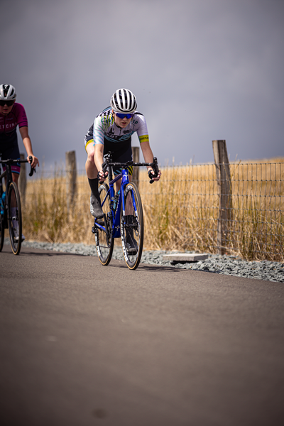 Two cyclists riding on a road. The lead cyclist is wearing the number 9.