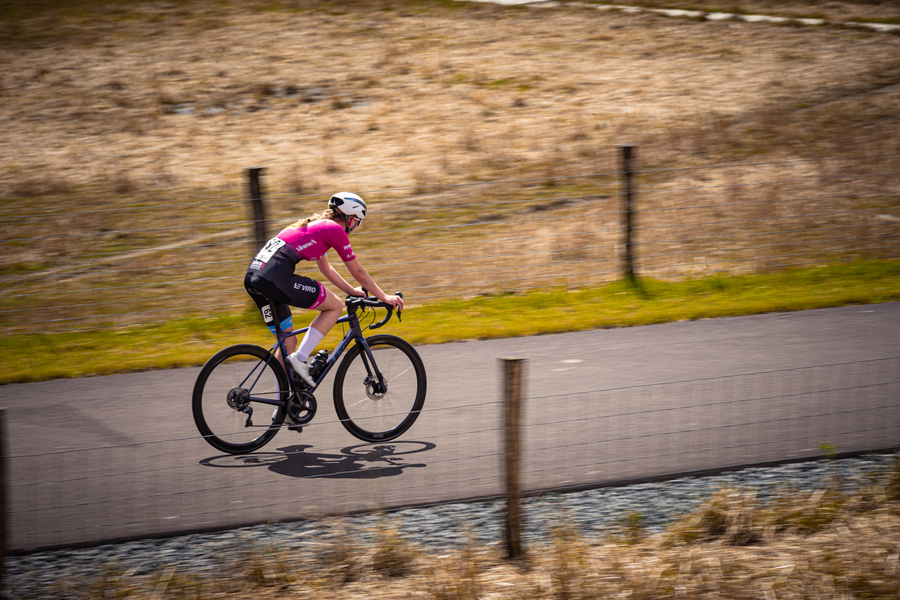 A woman on a pink bicycle with the number 5 on it.