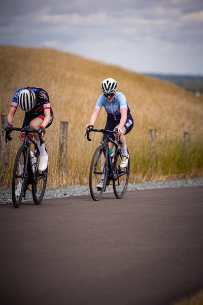 Two cyclists race across a field during the Nederlands Kampioenschap.