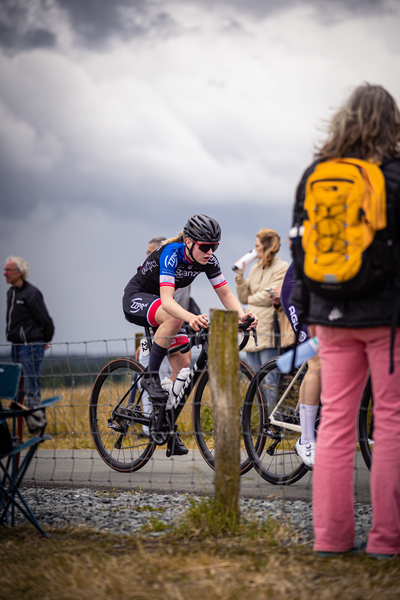 A woman riding a bike and the words "Junioren Dames" on her shirt.