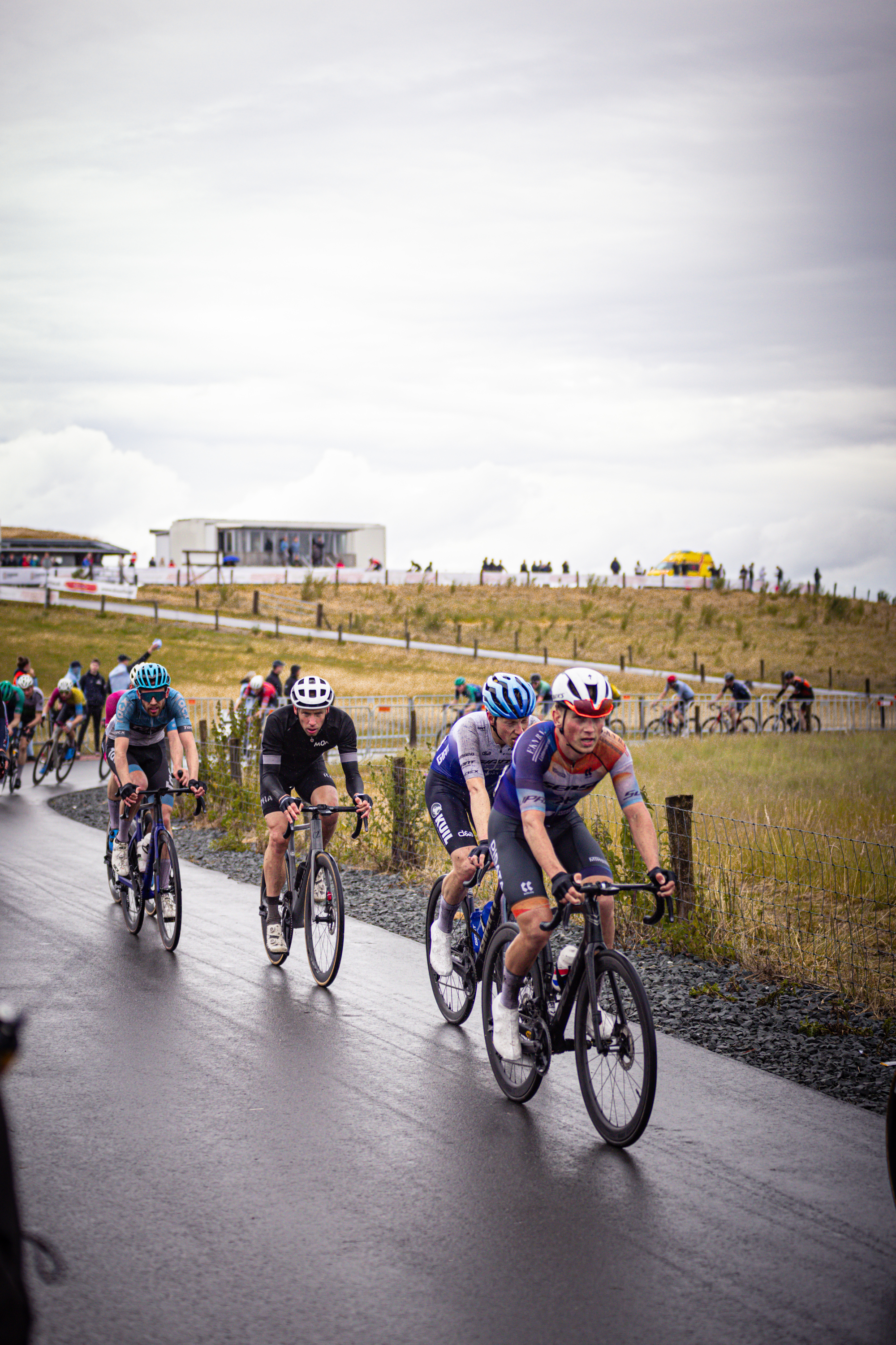 Bikes being ridden by people in a group, one man is wearing number 14 on his shirt.