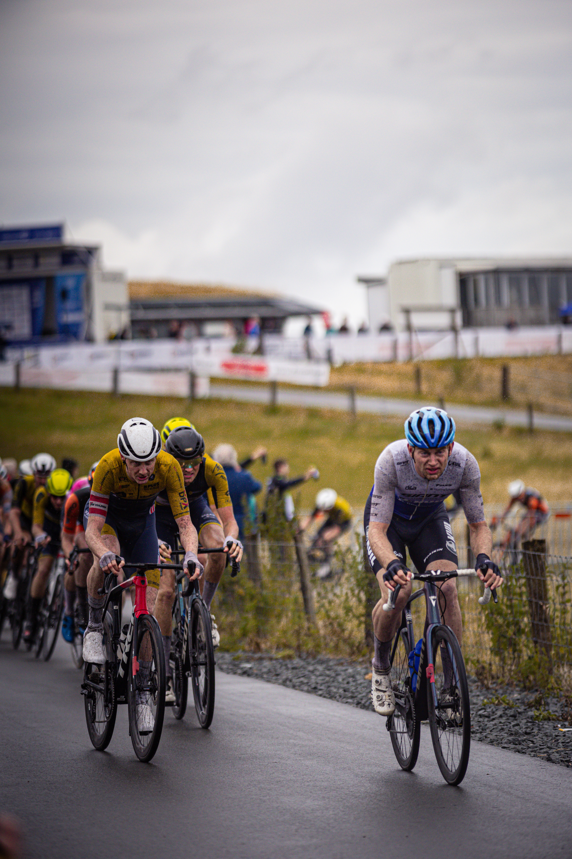 Two cyclists riding on a street, one of which is wearing the number 9 on his jersey.