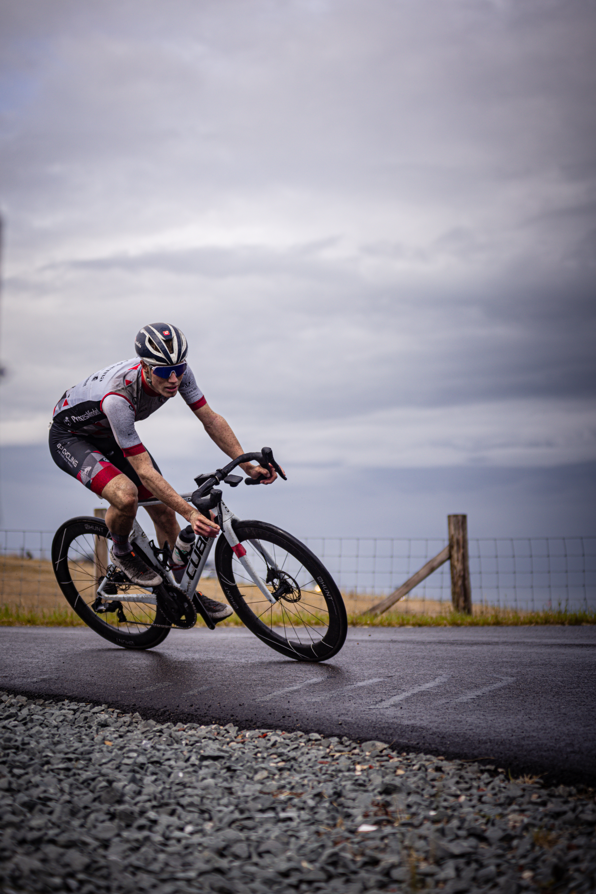 A person wearing a helmet is riding a black bicycle.