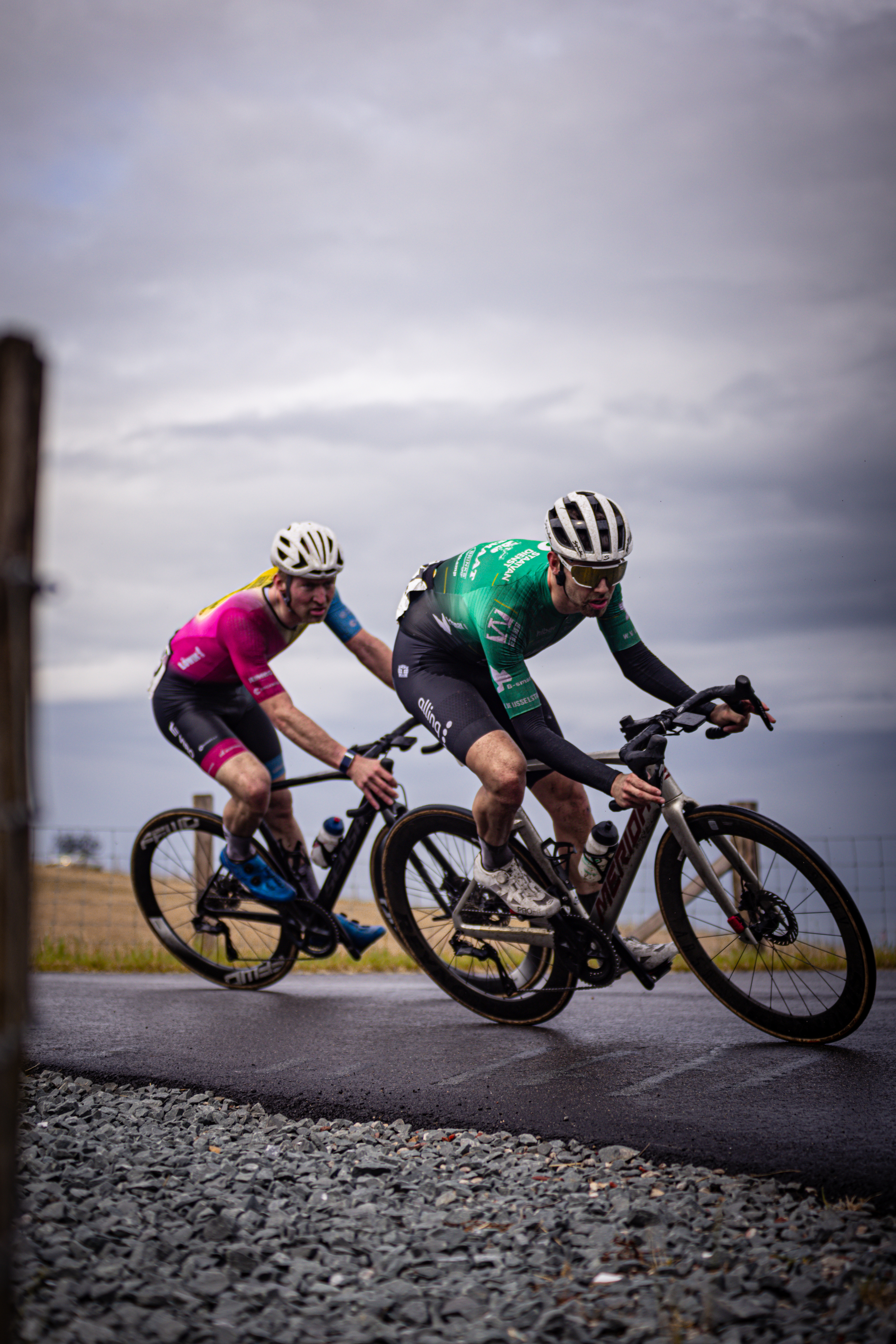 Two cyclists are racing on a gravel road in the Netherlands.