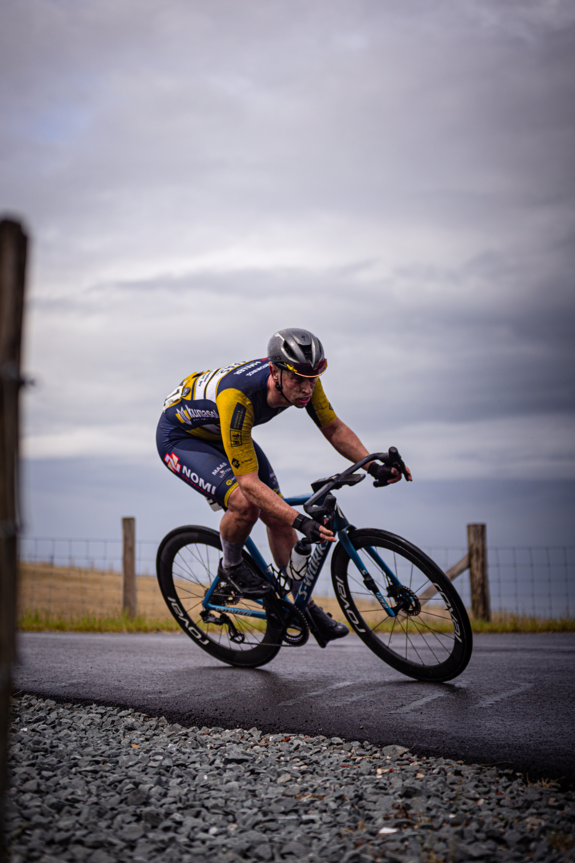 A man racing his bicycle and the name of Nederlands Kampioenschap.