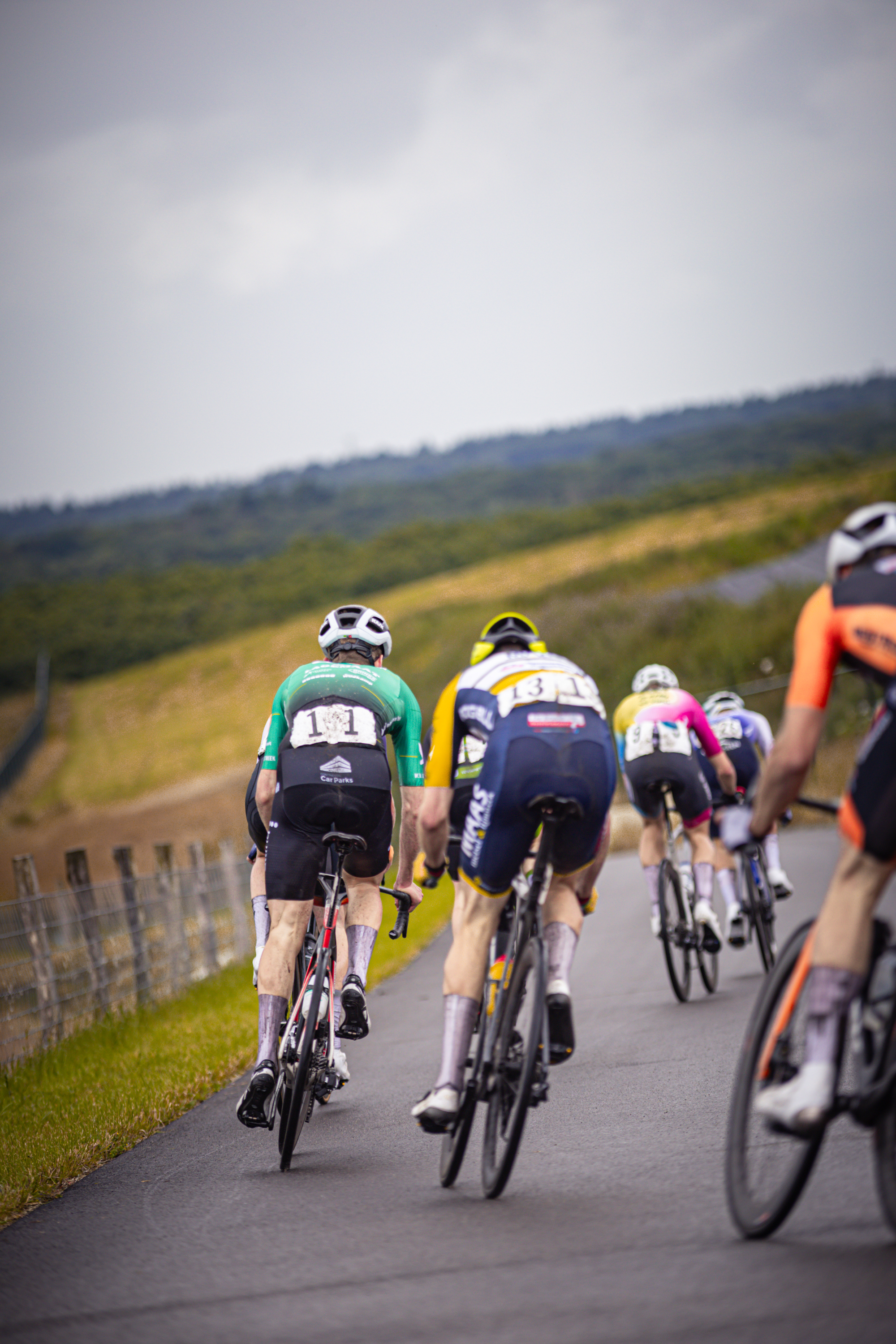 A group of cyclists race down a country road during the Nederlands Kampioenschap.