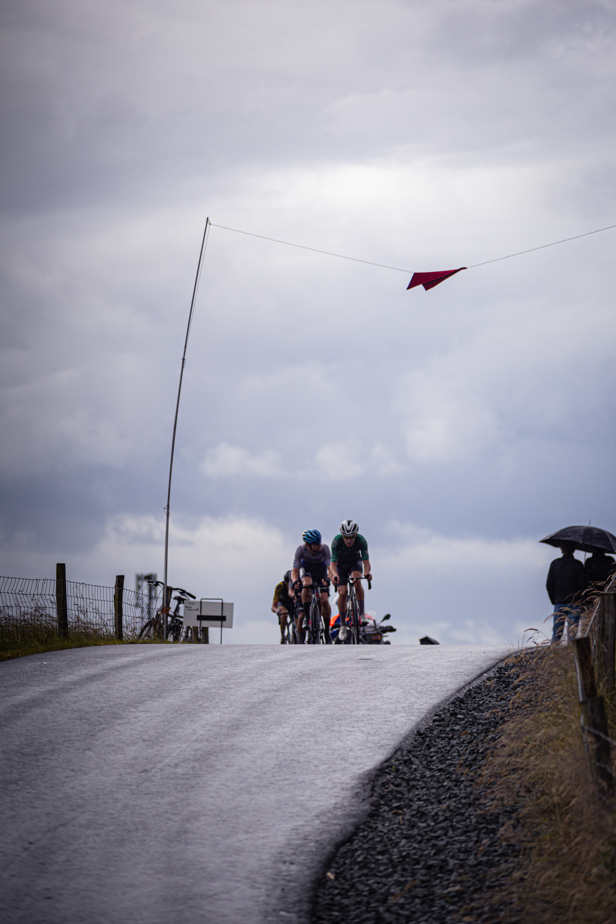 A group of cyclists are riding on a road, with the name "Mannen Elite ZC" on their backs.