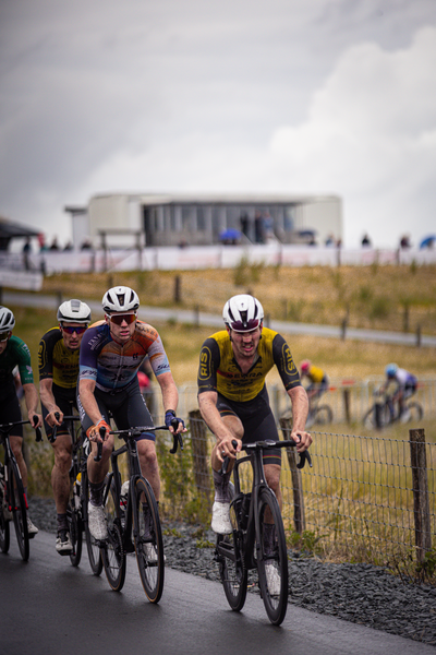 The cyclists are wearing helmets and riding bikes.