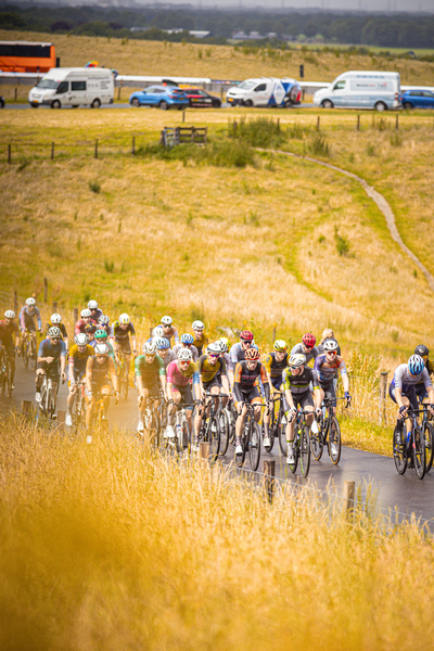 A group of people are riding bicycles in a field during Nederlands Kampioenschap.